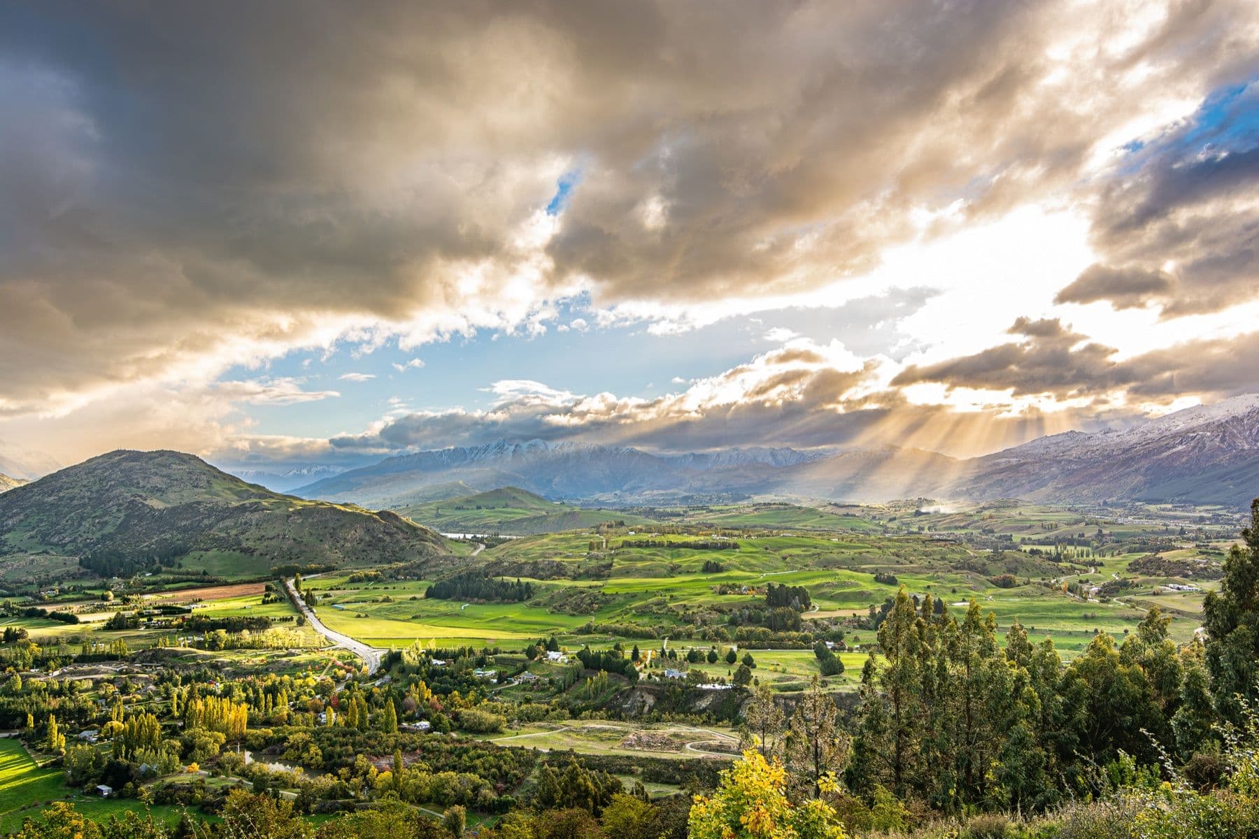 Sunlight breaking through cloud over an empty mountain valley