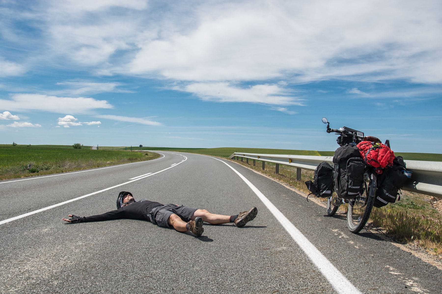 Lying flat on my back in the middle of an empty road, the loaded touring bike waiting at the guardrail